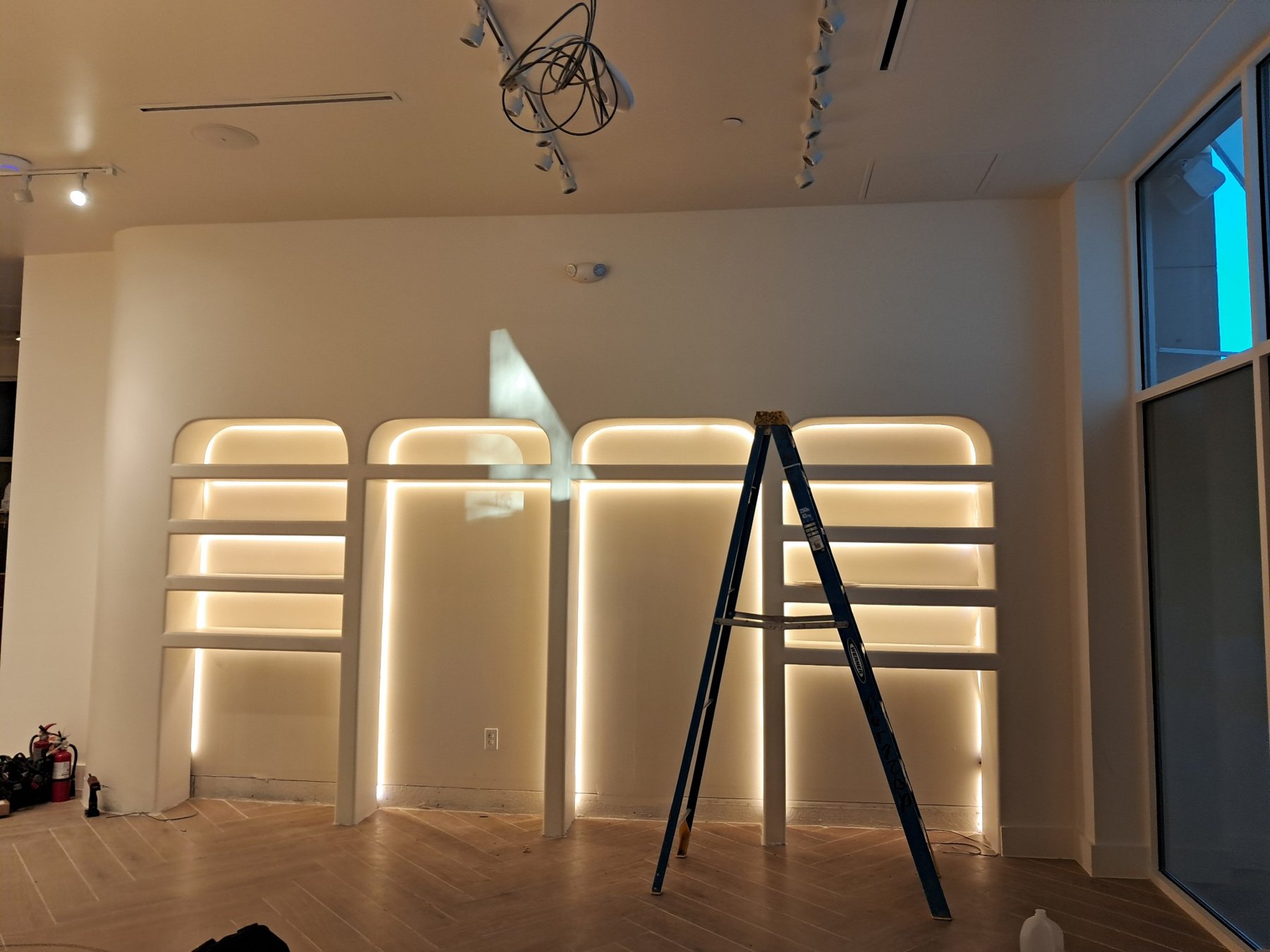 Finished commercial interior with backlit LED feature wall wired by A.H. Electrical