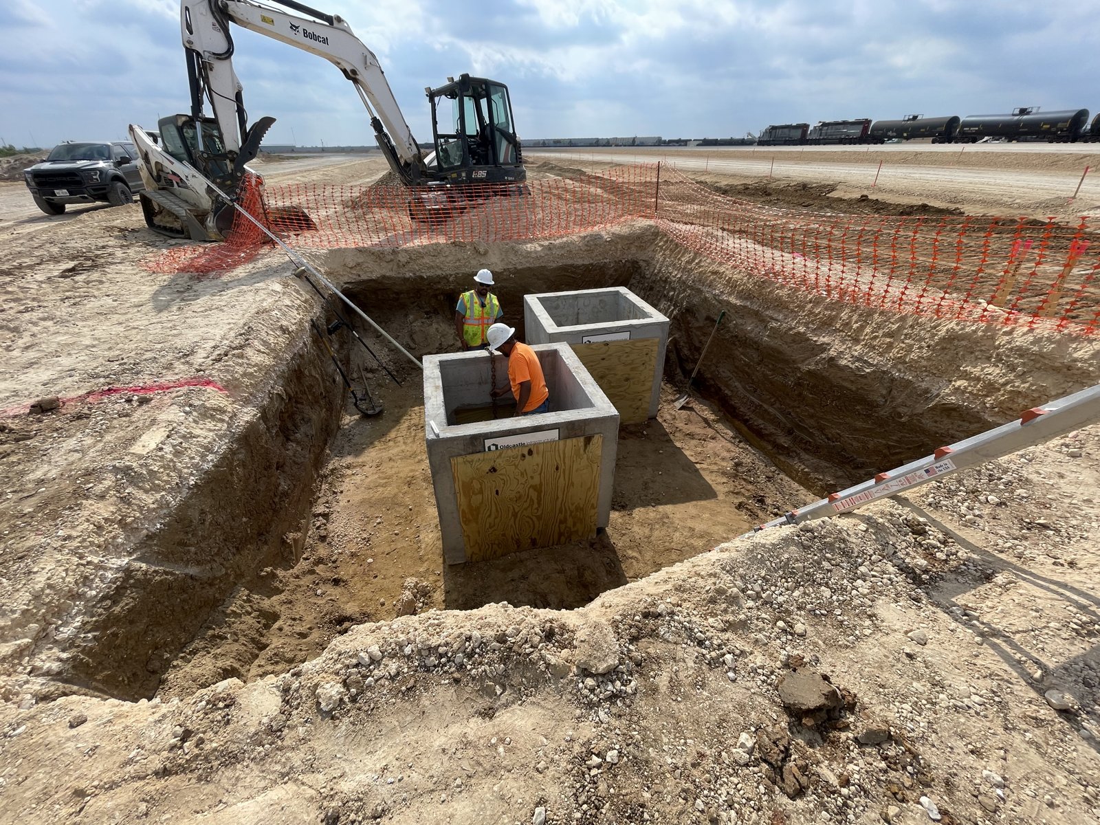 Setting concrete equipment vaults in an excavation at a commercial site
